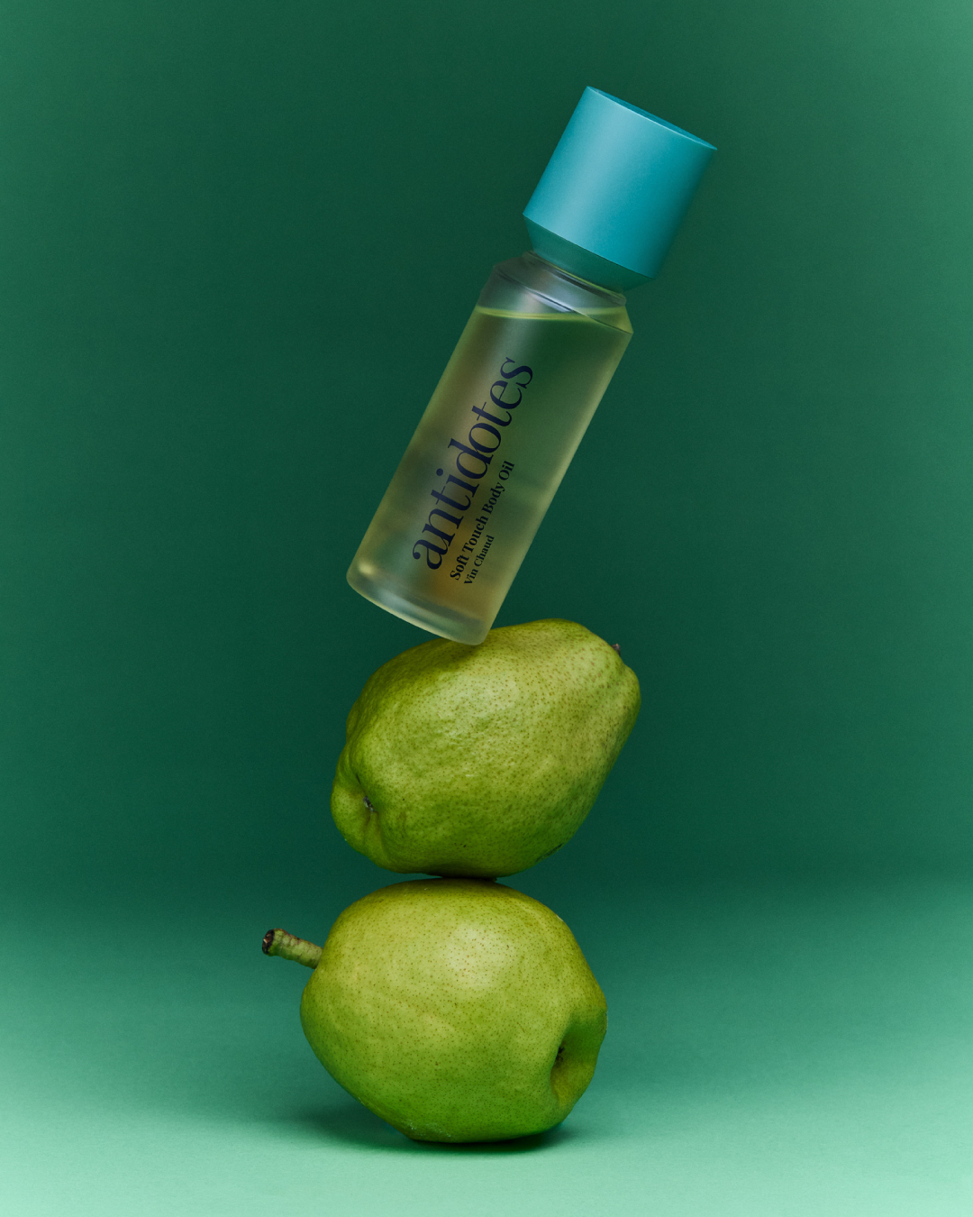 Two Antidotes Soft Touch Body Oil bottles on a pale studio backdrop